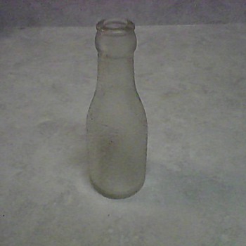 A SMALL OVERSHOT GLASS BOTTLE