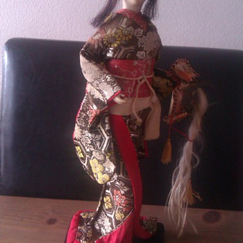 Old geisha doll with samurai helmet