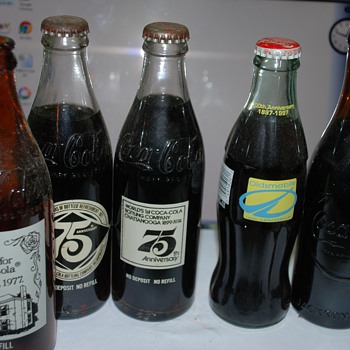 A small collection of Full Coca Cola anniversary bottles - Coca-Cola