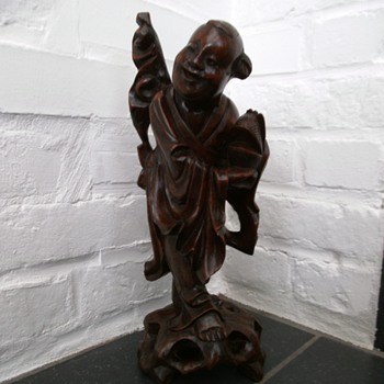 asian wooden carved smiling person (buddha?)