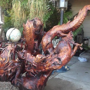 Wood carving of two dragons fighting over pearl of wisdom - Asian