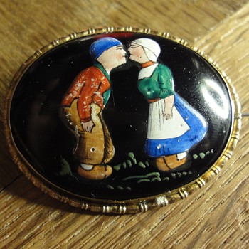 An enamal brooch with couple in traditional costumes