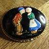 An enamal brooch with couple in traditional costumes