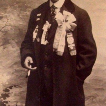 Photo c. 1912, MAN SMOKES WITH A CHEST FULL OF PRIZE RIBBONS. (FOR WHAT?) - Photographs