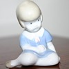 Small Porcelain Figurine - Little girl sitting - unmarked - Need help to identify