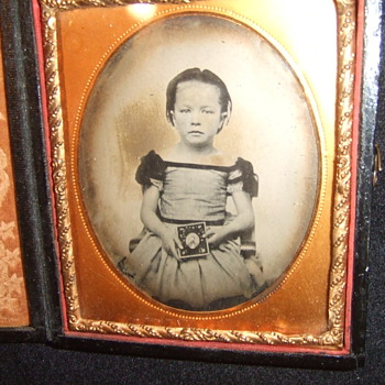Child holds a photograph of a man - Photographs