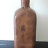 dark brown glass leather covered bottle