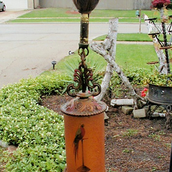 Painted bird on glass cylinder in ceiling fixture