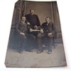 Tintype of men with stereoscope and card on table