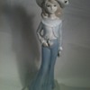 A PORCELAIN GIRL WITH BIG PANTS AND BIG HAT .