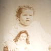 Cabinet card of a Girl holding a large doll