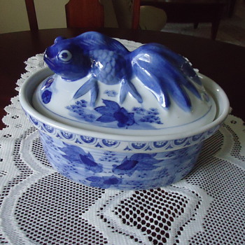 BLUE AND WHITE BOWL WITH FISH ON COVER.