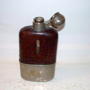 Cut glass flask with leather covering and a removable cup...silver