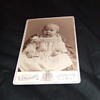 Cabinet card of child holding a nail c. 1880