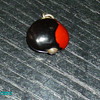 bean type charm with silver pin through it