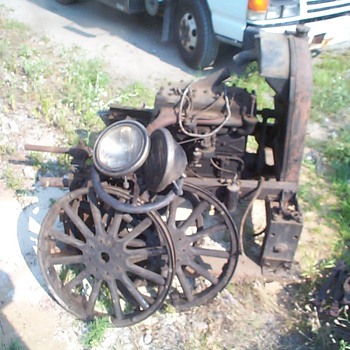 early flathead engine, with headlights , steering wheel, three tire rims