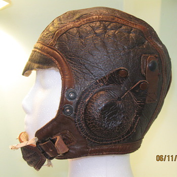 Aviator cap, metal toy gun, old eyeglasses, postcards