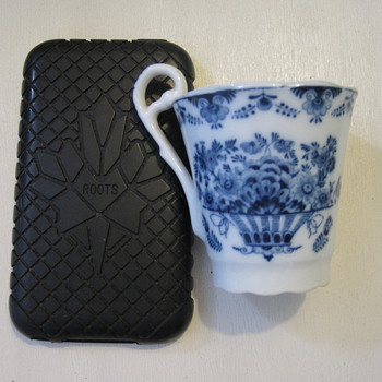 Diminutive blue and white cup with distinctive handle