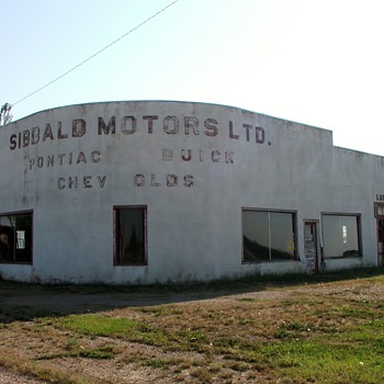 Old deserted Car Dealership . I love the shape of it .