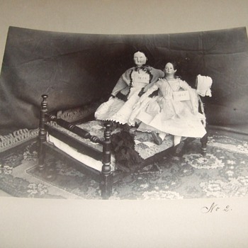 Dolls displayed on doll sized rope bed