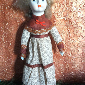 Blond Haired Porcelain Bisque Doll in Brown Calico Dress, unknown age or maker - Dolls