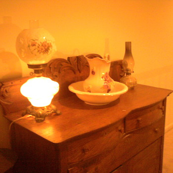 This is an turn of the century dresser and antique hurricane lamp. The Washbowl dates to 1885..