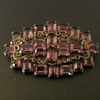 Faceted purple stones set in base metal