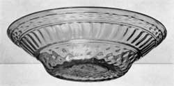 Illustration II: A Magnificent Blown-Three-Mold Bowl: Of brilliant clear green glass, light tone, this piece was probably blown at Kent, Ohio, in a decanter mold. The pattern consists of vertical ribbing between wide bands of diamond diapering. The band of gadrooning which encircles the shoulder in decanters has been almost entirely lost or obliterated in expansion of the bowl. Several of these bowls are known in light green glass and three or four in a glass of olive-yellow tone. This bowl is, so far as known, unique in size and widespread sides. Illustration II: A Magnificent Blown-Three-Mold Bowl: Of brilliant clear green glass, light tone, this piece was probably blown at Kent, Ohio, in a decanter mold. The pattern consists of vertical ribbing between wide bands of diamond diapering. The band of gadrooning which encircles the shoulder in decanters has been almost entirely lost or obliterated in expansion of the bowl. Several of these bowls are known in light green glass and three or four in a glass of olive-yellow tone. This bowl is, so far as known, unique in size and widespread sides.