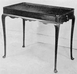 A New England Tea Table: Made of mahogany, with its molded top, clover leaf corners, slender cabriole legs and Dutch feet, this is a very graceful design delicately executed. A New England Tea Table: Made of mahogany, with its molded top, clover leaf corners, slender cabriole legs and Dutch feet, this is a very graceful design delicately executed.