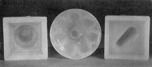 Bases of Original Candlesticks: Left to right, a fluted-column candlestick that is hollow the length of base and column; center, a loop-and-petal design showing roughness where pontil rod was, affixed; right, a single base dolphin design. In the copies of the latter the open space within the dolphin head is wider and noticeably deeper. Bases of Original Candlesticks: Left to right, a fluted-column candlestick that is hollow the length of base and column; center, a loop-and-petal design showing roughness where pontil rod was, affixed; right, a single base dolphin design. In the copies of the latter the open space within the dolphin head is wider and noticeably deeper.