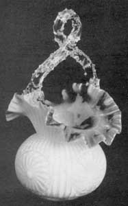 Basket with Applied Flowers: The body is of a pale green opaque glass picked over transparent glass of the same color. The applied flower is of clear yellow, and the looped handle of clear glass. Originally pressed in a mold and shaped when pliable. Height, 8 inches; width, 5 inches. Basket with Applied Flowers: The body is of a pale green opaque glass picked over transparent glass of the same color. The applied flower is of clear yellow, and the looped handle of clear glass. Originally pressed in a mold and shaped when pliable. Height, 8 inches; width, 5 inches.