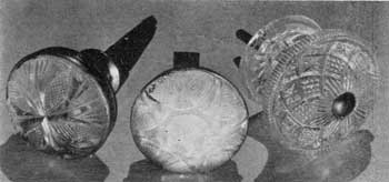 Cut Glass and Cast Compared: The two with cut-glass faces are mounted in brass bases. One retains the reflecting mirror behind the glass so that it appears to be of opalescent glass. At the right a cast-glass knob of intricate geometric pattern that seems to be also of lacy Sandwich in its design. Cut Glass and Cast Compared: The two with cut-glass faces are mounted in brass bases. One retains the reflecting mirror behind the glass so that it appears to be of opalescent glass. At the right a cast-glass knob of intricate geometric pattern that seems to be also of lacy Sandwich in its design.