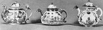 Illustration V (A, B, C): Dresden Teapots Showing Development in Design: A — Made circa 1712-1715 and unmarked, was decorated with engraved gold foil attached with lacquer. B — Made 1720 and unmarked. Here the decoration was fired gold. C — Made circa 1725 and marked with the crossed swords. The decoration is polychrome painting in frames of iridescent purple. These are each six inches wide. Illustration V (A, B, C): Dresden Teapots Showing Development in Design: A — Made circa 1712-1715 and unmarked, was decorated with engraved gold foil attached with lacquer. B — Made 1720 and unmarked. Here the decoration was fired gold. C — Made circa 1725 and marked with the crossed swords. The decoration is polychrome painting in frames of iridescent purple. These are each six inches wide.