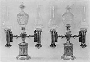 English Regency Period Lamps: The lighting fuel used in such lamps equipped with Argand burners was generally a refined sperm oil. This pair have Wedgwood jasper-ware bases, elaborate Waterford cut-glass decorative finials, and carefully blown glass chimneys so shaped as to make them the best source of artificial lighting possible. English Regency Period Lamps: The lighting fuel used in such lamps equipped with Argand burners was generally a refined sperm oil. This pair have Wedgwood jasper-ware bases, elaborate Waterford cut-glass decorative finials, and carefully blown glass chimneys so shaped as to make them the best source of artificial lighting possible.