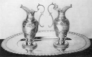 Illustration I: Ewers and Basin by Paul Lambert or Sieur Saint-Paul: This pair of ewers and basin were made by this Quebec silversmith circa 1725 for the Indian mission of Lorette. The basin is oval in shape. It is twelve inches long and nine inches wide. Illustration I: Ewers and Basin by Paul Lambert or Sieur Saint-Paul: This pair of ewers and basin were made by this Quebec silversmith circa 1725 for the Indian mission of Lorette. The basin is oval in shape. It is twelve inches long and nine inches wide.