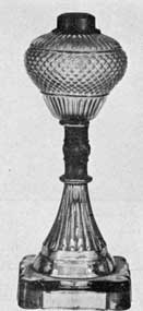 Exceedingly Rare Lamp: The pear-shaped bowl is blown molded in diamond diapering and vertical ribbing pattern. It is mounted by an ornamental brass ferule on a pressed glass base that is lime green in color. Exceedingly Rare Lamp: The pear-shaped bowl is blown molded in diamond diapering and vertical ribbing pattern. It is mounted by an ornamental brass ferule on a pressed glass base that is lime green in color.