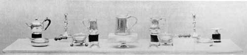 Made for Nicholas Sever, Harvard Tutor: All were the work of John Burt except for the cann altered into a pitcher, at the center right; that was the work of W. Simpkins. These pieces date from 1715 to 1728. Made for Nicholas Sever, Harvard Tutor: All were the work of John Burt except for the cann altered into a pitcher, at the center right; that was the work of W. Simpkins. These pieces date from 1715 to 1728.