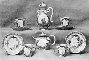 Illustration VI: Part of a Coffee Service: Made 1725-1727, these pieces have the crossed-swords mark — some underglaze and others overglaze. The decoration is scenes of commerce done in black and framed with iridescent purple and gold. The coffeepot is eight inches tall. Illustration VI: Part of a Coffee Service: Made 1725-1727, these pieces have the crossed-swords mark — some underglaze and others overglaze. The decoration is scenes of commerce done in black and framed with iridescent purple and gold. The coffeepot is eight inches tall.