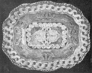 Illustration II- Vegetable Dish with Peacock-Eye Border: An important addition to Sandwich rarities is illustrated in this large open vegetable dish. The flat brim is decorated with scrolled peacock eyes. The principal decorative motifs of the design are those that were most frequently employed by Sandwich, including the lyre, thistle, and basket of fruit. Dimensions are 10 by 8.5 inches. Illustration II- Vegetable Dish with Peacock-Eye Border: An important addition to Sandwich rarities is illustrated in this large open vegetable dish. The flat brim is decorated with scrolled peacock eyes. The principal decorative motifs of the design are those that were most frequently employed by Sandwich, including the lyre, thistle, and basket of fruit. Dimensions are 10 by 8.5 inches.