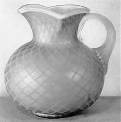 Pitcher of Mother-of-Pearl Glass: In color, this piece is a brilliant pastel blue which is set off by the lattice of the exterior, the translucent handle, and the rim at the mouth. Pitcher of Mother-of-Pearl Glass: In color, this piece is a brilliant pastel blue which is set off by the lattice of the exterior, the translucent handle, and the rim at the mouth.