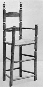 Slat-Back High Chair: Made late in the 17th Century, the finials, ring turnings, and buttons on the front legs characterized many American chairs made until early in the 18th Century. Slat-Back High Chair: Made late in the 17th Century, the finials, ring turnings, and buttons on the front legs characterized many American chairs made until early in the 18th Century.