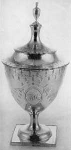 Sugar Bowl by Gilbert: The urn shape was a favorite form with this silversmith. This piece, with "bright-cut" engraved decoration, bears the monogram T H L in the oval beneath the balancing leafage sprays on the side. Sugar Bowl by Gilbert: The urn shape was a favorite form with this silversmith. This piece, with "bright-cut" engraved decoration, bears the monogram T H L in the oval beneath the balancing leafage sprays on the side.