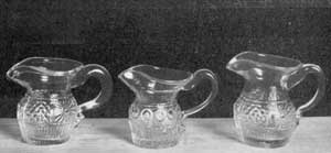 Illustration III: Three Miniature Cream Pitchers: Those at the right and the left are a pair and match the pattern of the decanters in Illustration II. The center one is a unique specimen. All of these were finished by hand and vary slightly in size and shape. Illustration III: Three Miniature Cream Pitchers: Those at the right and the left are a pair and match the pattern of the decanters in Illustration II. The center one is a unique specimen. All of these were finished by hand and vary slightly in size and shape.