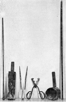 Paperweight Tools: Left to Right these are: a blow-pipe and gathering iron; a wooden pallet for farming various sizes of feet for paperweights; a glassworker's pincers that had many uses, such as finishing a foot, and shaping the well of an inkstand; shears used to cut bits of molten glass; a block used to give paperweights their spherical shape; and a pontil rod, on which a paperweight was held while being made. Paperweight Tools: Left to Right these are: a blow-pipe and gathering iron; a wooden pallet for farming various sizes of feet for paperweights; a glassworker's pincers that had many uses, such as finishing a foot, and shaping the well of an inkstand; shears used to cut bits of molten glass; a block used to give paperweights their spherical shape; and a pontil rod, on which a paperweight was held while being made.