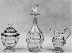 2. Clear bowl, decanter and creamer: Part of a table set made by the New England Glass Company before 1850. The design, the Ashburton pattern, consists of a row of ovals above and between a row of loops. A Pair of 16-inch celery vases and a globular compote in the Thumbprint pattern. Their grace and brilliance are similar to English or Irish cut glass. Probably made by Bakewell, Pears and Company in the '60s. 2. Clear bowl, decanter and creamer: Part of a table set made by the New England Glass Company before 1850. The design, the Ashburton pattern, consists of a row of ovals above and between a row of loops. A Pair of 16-inch celery vases and a globular compote in the Thumbprint pattern. Their grace and brilliance are similar to English or Irish cut glass. Probably made by Bakewell, Pears and Company in the '60s.