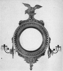 Bull's Eye Mirror Sconce: A handsomely carved and gilded piece made in New York about 1800, the circular convex mirror reflected the light of the four candles placed in the sconce arm at either side. Bull's Eye Mirror Sconce: A handsomely carved and gilded piece made in New York about 1800, the circular convex mirror reflected the light of the four candles placed in the sconce arm at either side.