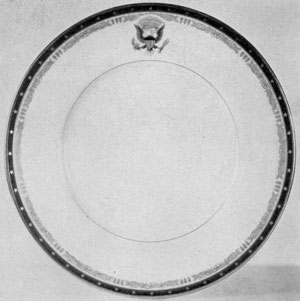 Designed by Franklin Delano Roosevelt: In this White House dinner service the outer border is under mat cobalt blue with gold stars. The motifs of the inner border are a rose and three feathers adapted from the Roosevelt coat-of-arms. The Presidential seal, also on the rim, is executed in colors. Designed by Franklin Delano Roosevelt: In this White House dinner service the outer border is under mat cobalt blue with gold stars. The motifs of the inner border are a rose and three feathers adapted from the Roosevelt coat-of-arms. The Presidential seal, also on the rim, is executed in colors.