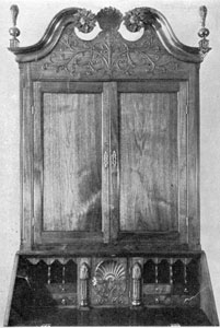 Detail of Two Bachman Secretaries: Notice the differences in motif of the carved ornamentation on the bonnet tops, and variation in shaping and placement of the flame finials. The secretary at the left was made circa 1780-1800; that at the right circa 1766-1770. detailoftwobachmann2