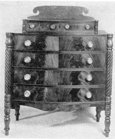 An Empire Chest of Drawers: Of mahogany with drawer fronts characteristically of crotch-grain veneer, this piece when in the Warren Cramer Collection was attributed to Joseph Cushing who worked in Boston about 1820. An Empire Chest of Drawers: Of mahogany with drawer fronts characteristically of crotch-grain veneer, this piece when in the Warren Cramer Collection was attributed to Joseph Cushing who worked in Boston about 1820.
