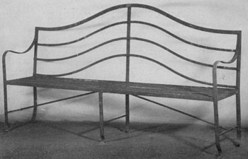 A Garden Bench in Hepplewhite Style: The cresting members of the back, the use of reeding and the small paw feet are its decorative features. A Garden Bench in Hepplewhite Style: The cresting members of the back, the use of reeding and the small paw feet are its decorative features.